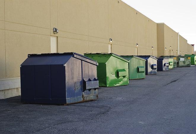 a fleet of red and blue construction dumpsters available for use in Hamilton